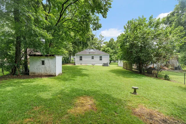 a house is sitting in middle od the grass