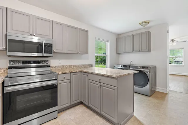 a kitchen with granite countertop a stove microwave and sink