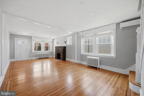 a view of empty room with wooden floor and fireplace