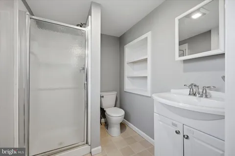 a bathroom with a sink toilet vanity and shower