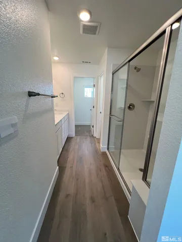 a view of a hallway with wooden floor and staircase