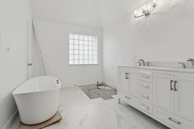 a spacious bathroom with a bathtub a sink and a window