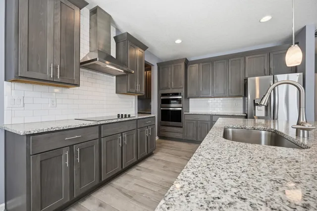 a kitchen with stainless steel appliances granite countertop a sink stove and cabinets