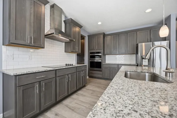 a kitchen with stainless steel appliances granite countertop a sink stove and cabinets