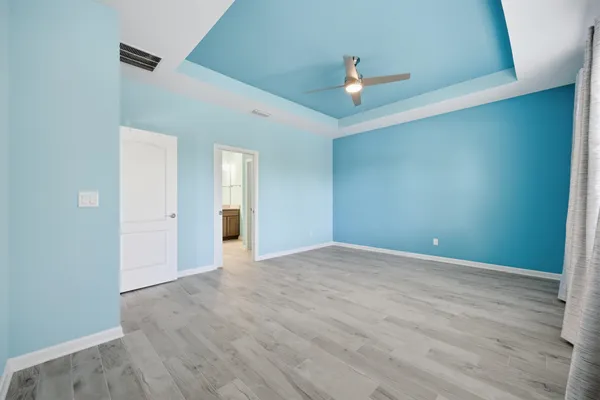 an empty room with a window and a fan