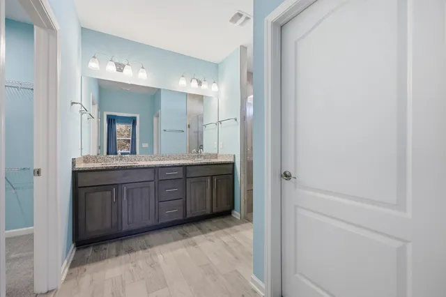 a bathroom with a granite countertop sink a large mirror and shower