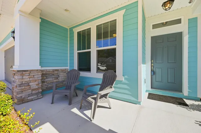 a balcony with table and chairs and a barbeque