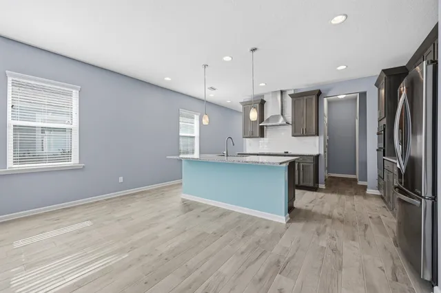 a kitchen with stainless steel appliances granite countertop a sink a counter space and wooden floors
