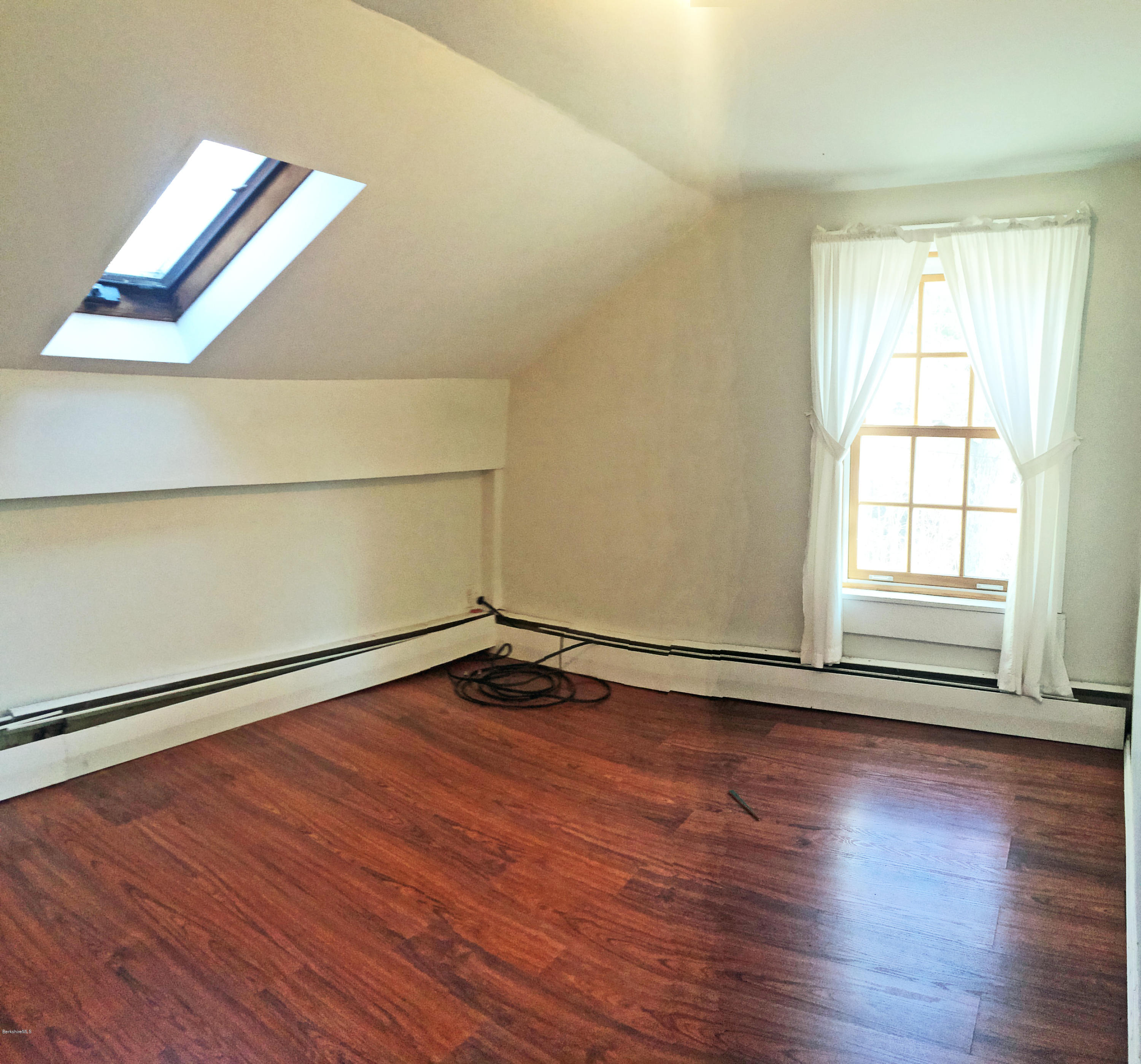 55 Sandisfield Road Sandisfield, MA 01255 - Photo 17 of 20 an empty room with wooden floor and windows