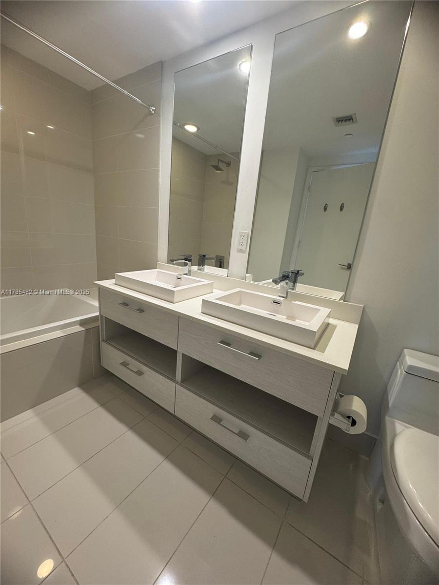 Brickell Miami, FL 33130 - Photo 10 of 12 a bathroom with a sink a toilet and a mirror