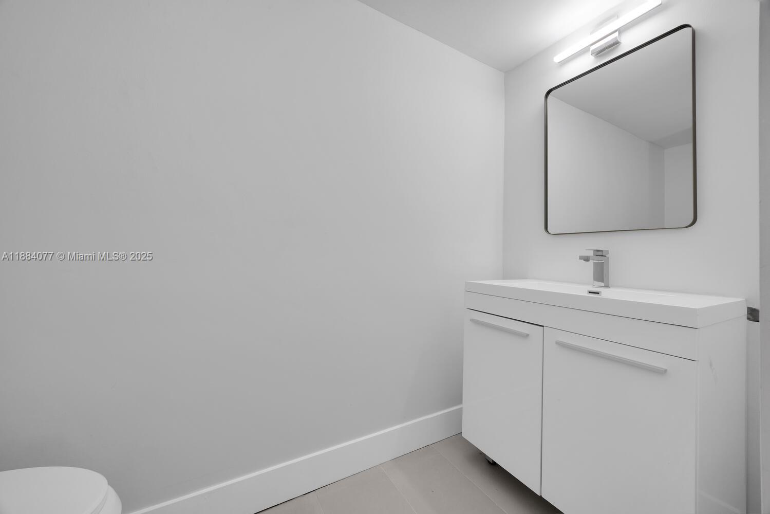 11500 Southwest 64th Street, Unit H Miami, FL 33173 - Photo 19 of 38 a bathroom with a toilet sink and mirror