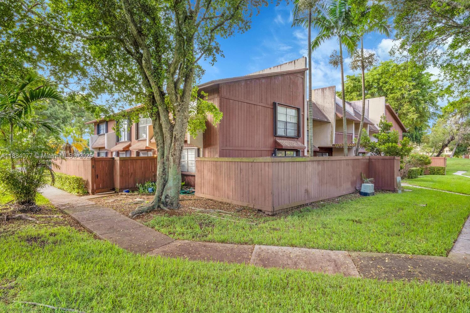 11500 Southwest 64th Street, Unit H Miami, FL 33173 - Photo 2 of 38 a view of backyard with a barn and large trees