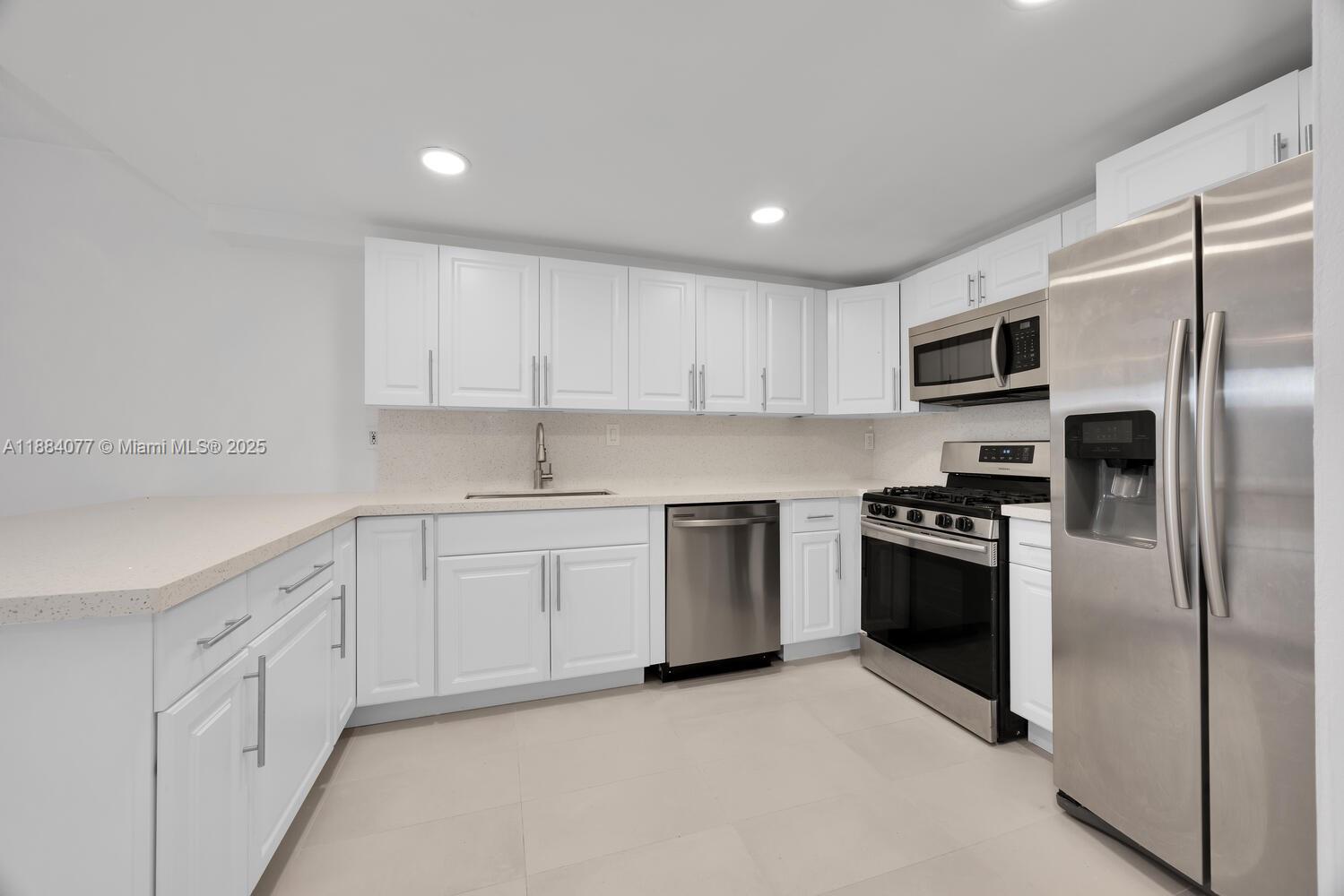 11500 Southwest 64th Street, Unit H Miami, FL 33173 - Photo 10 of 38 a kitchen with granite countertop white cabinets and stainless steel appliances