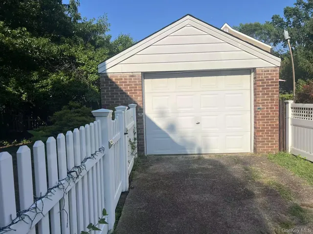 a view of a small house with wooden fence
