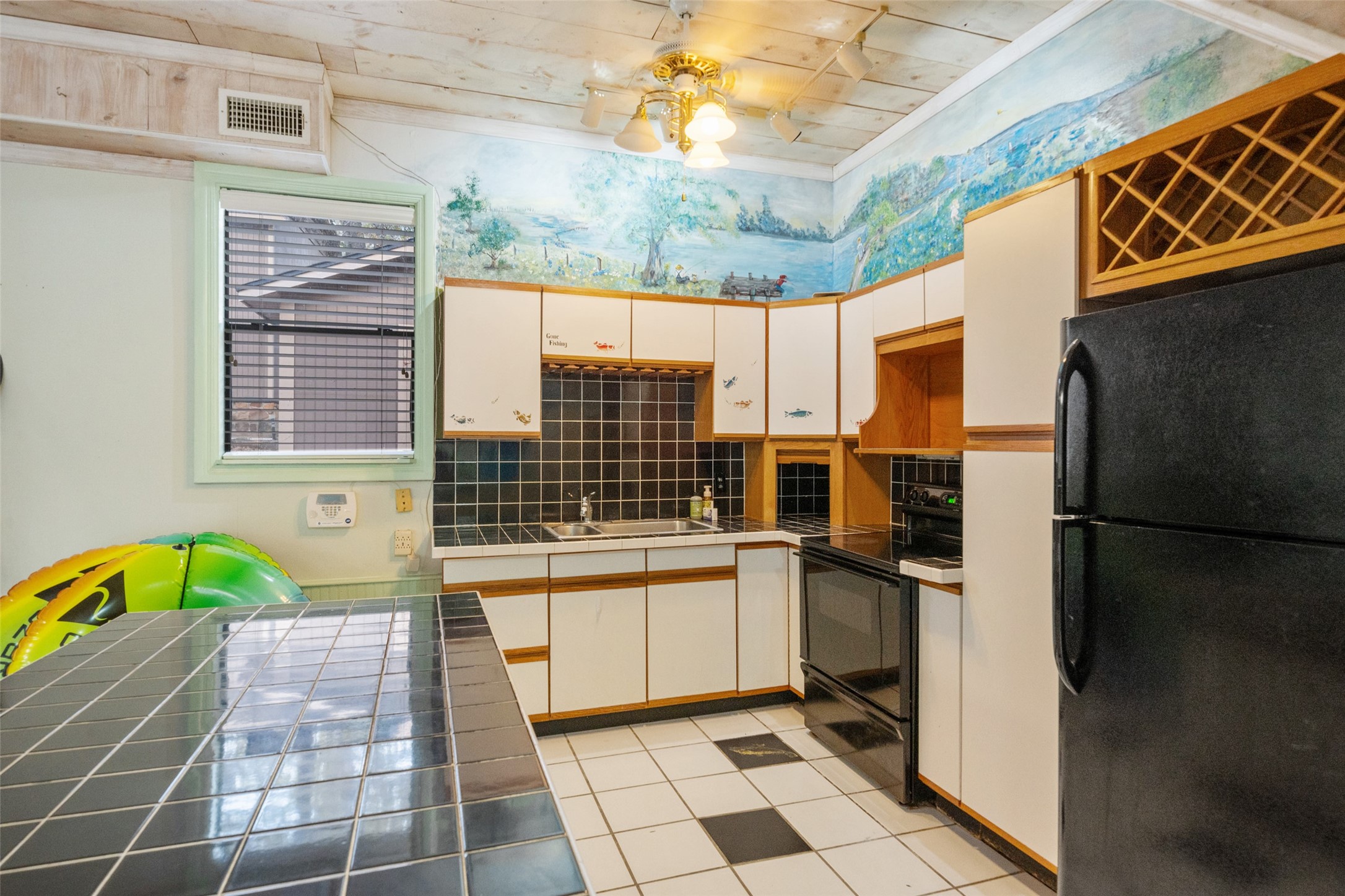 186 Lake Road Huntsville, TX 77320 - Photo 13 of 48 a view of a kitchen with a sink and a refrigerator