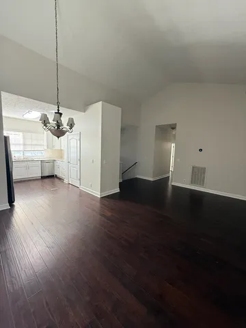 a view of a room with wooden floor ceiling fan and window
