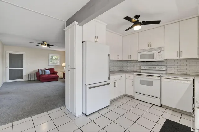 a kitchen with white cabinets and white appliances