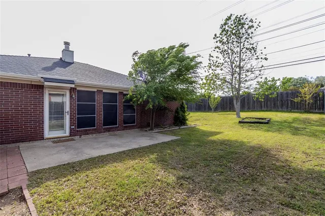 a view of a house with backyard and a tree