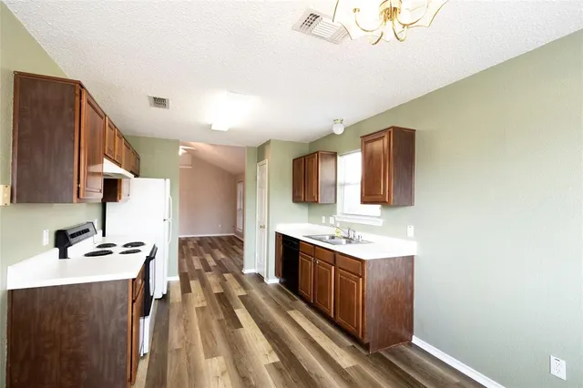 a kitchen with a sink appliances and cabinets