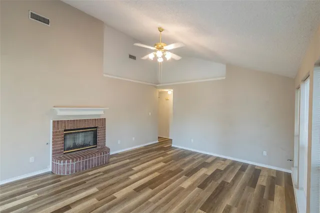 a view of wooden floor fire place refrigerator and window in a room