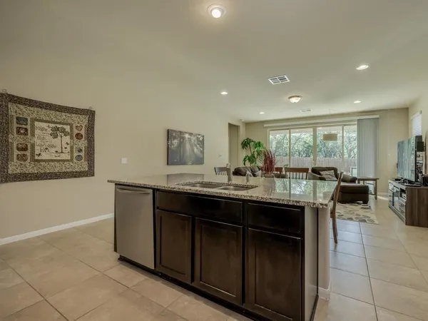 a backyard of a house with table and chairs potted plants and a large tree