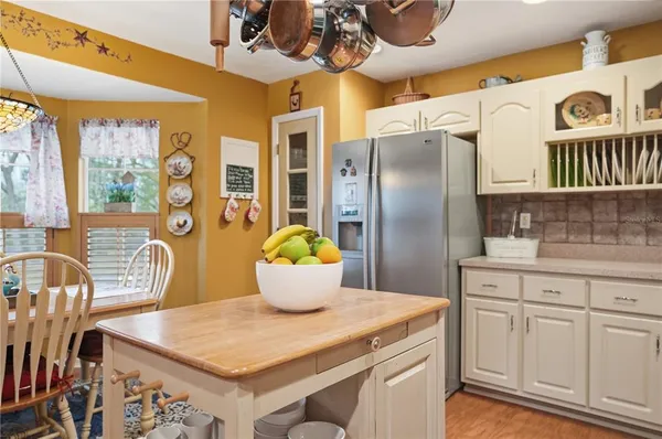 a kitchen with stainless steel appliances granite countertop a table chairs and a refrigerator