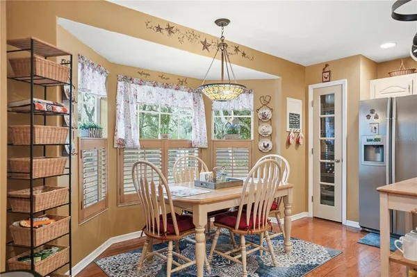 a dining room with furniture a chandelier and wooden floor