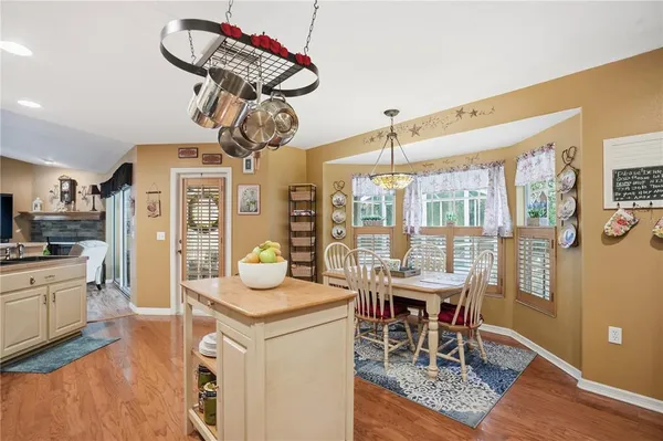 a dining room with furniture a chandelier and wooden floor