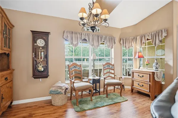 a living room with furniture a chandelier and a large window