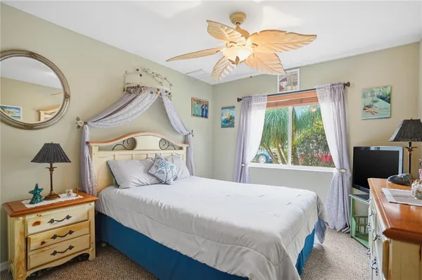 a bedroom with a bed a chandelier and a dresser