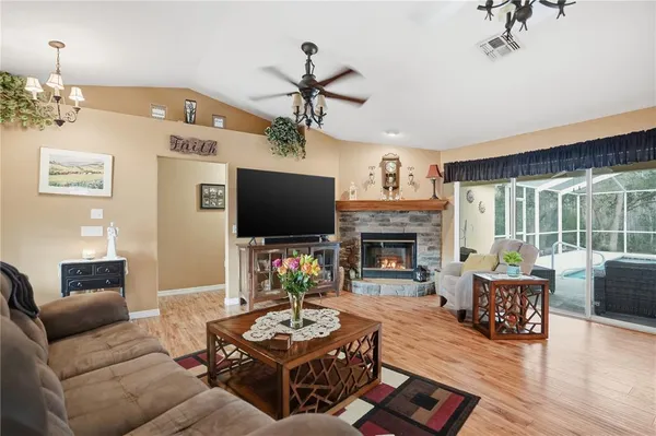 a living room with furniture a fireplace a flat screen tv and potted plant