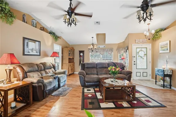 a living room with furniture a chandelier and a rug