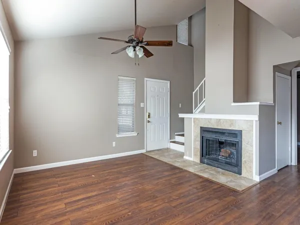 a view of an empty room with a fireplace and a window