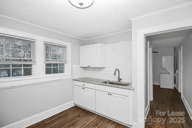 a kitchen with a sink window and cabinets