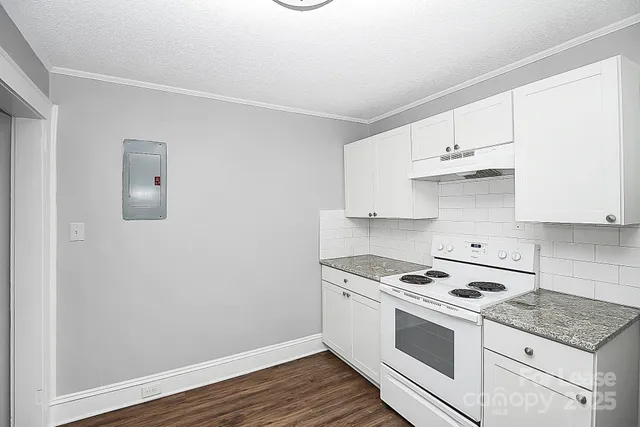 a kitchen with granite countertop white cabinets and white appliances