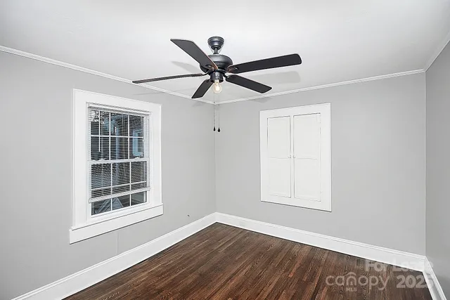 a view of a big room with wooden floor and windows