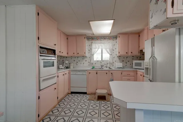 a kitchen with granite countertop appliances cabinets and a sink