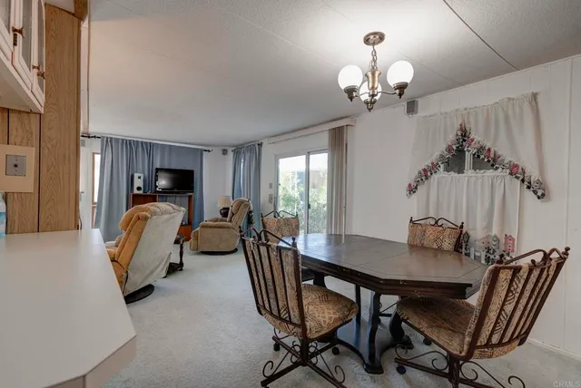 a view of a dining room with furniture and chandelier