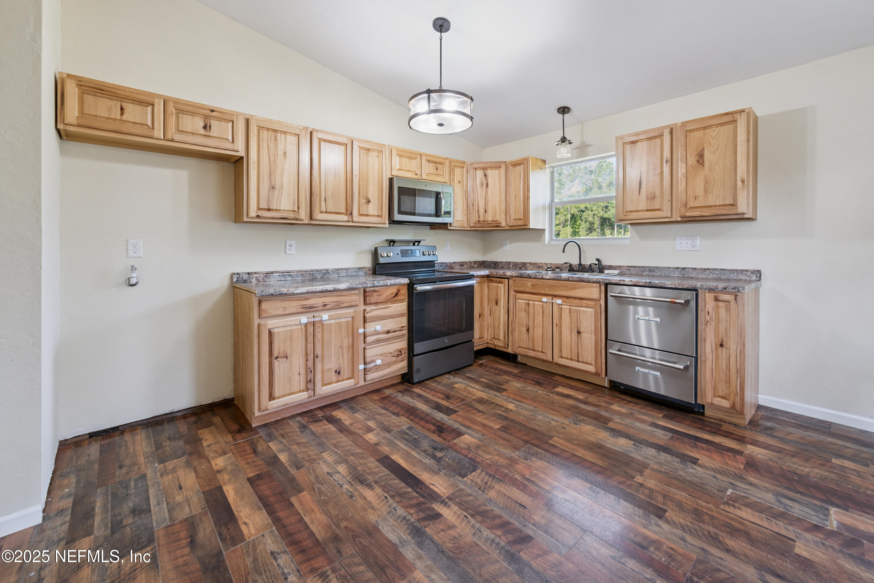 4881 Southwest 136th Court Lake Butler, FL 32054 - Photo 9 of 25 a kitchen with stainless steel appliances granite countertop a stove top oven a sink dishwasher and a microwave oven with wooden floor