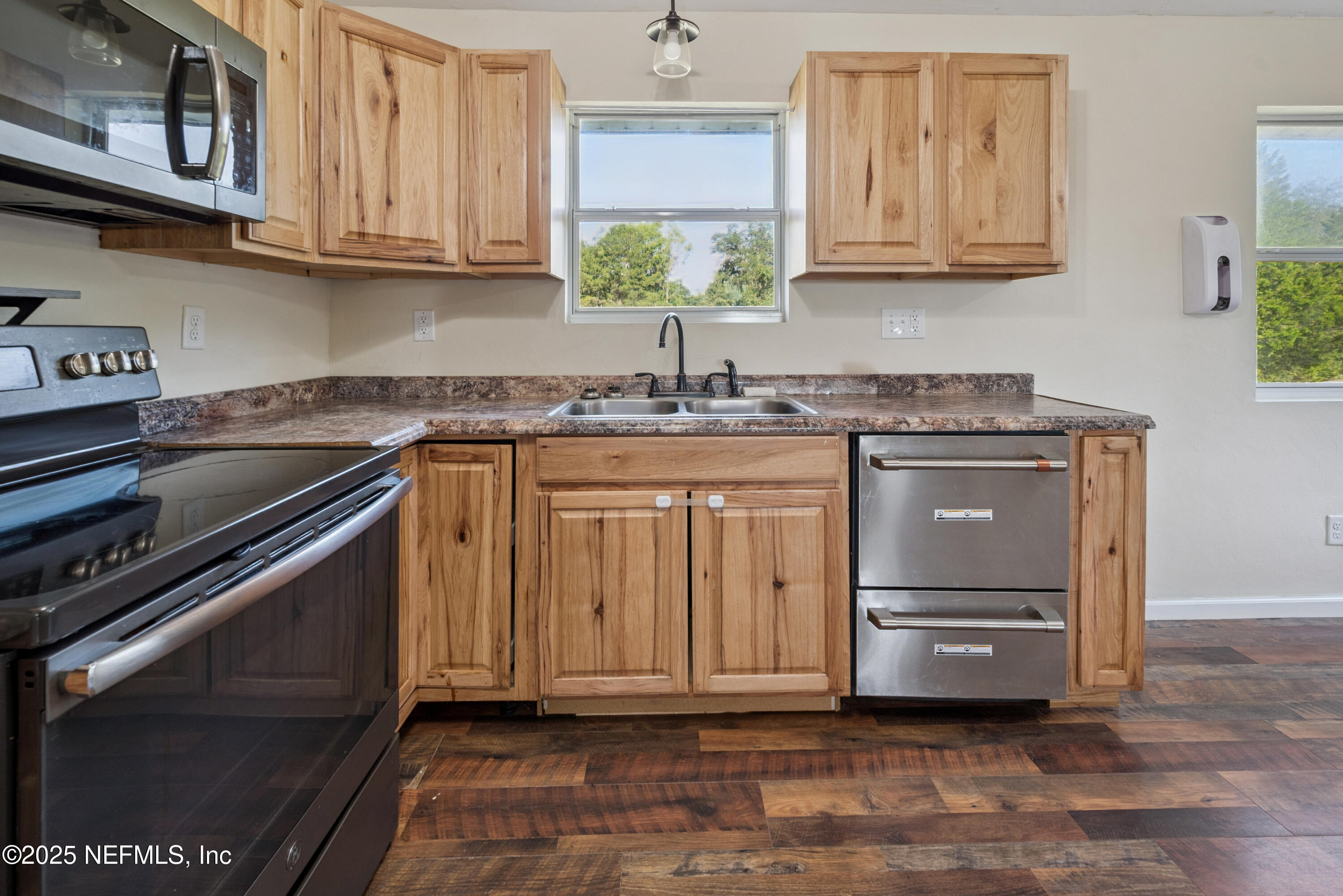 4881 Southwest 136th Court Lake Butler, FL 32054 - Photo 10 of 25 a kitchen with stainless steel appliances granite countertop a stove a sink and a microwave