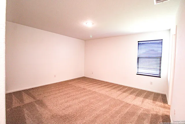 an empty room with a white walls and a window