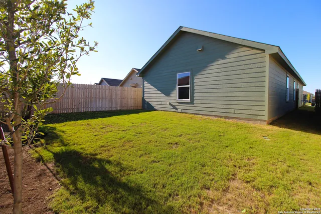 a view of backyard with wooden fence