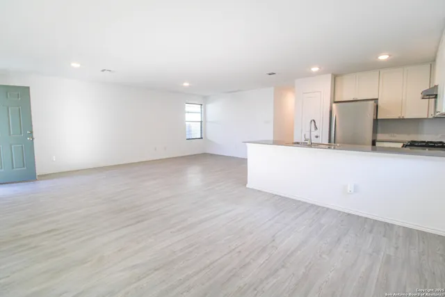 a view of a kitchen with a sink and a refrigerator