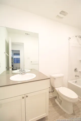 a bathroom with a toilet a sink and a mirror