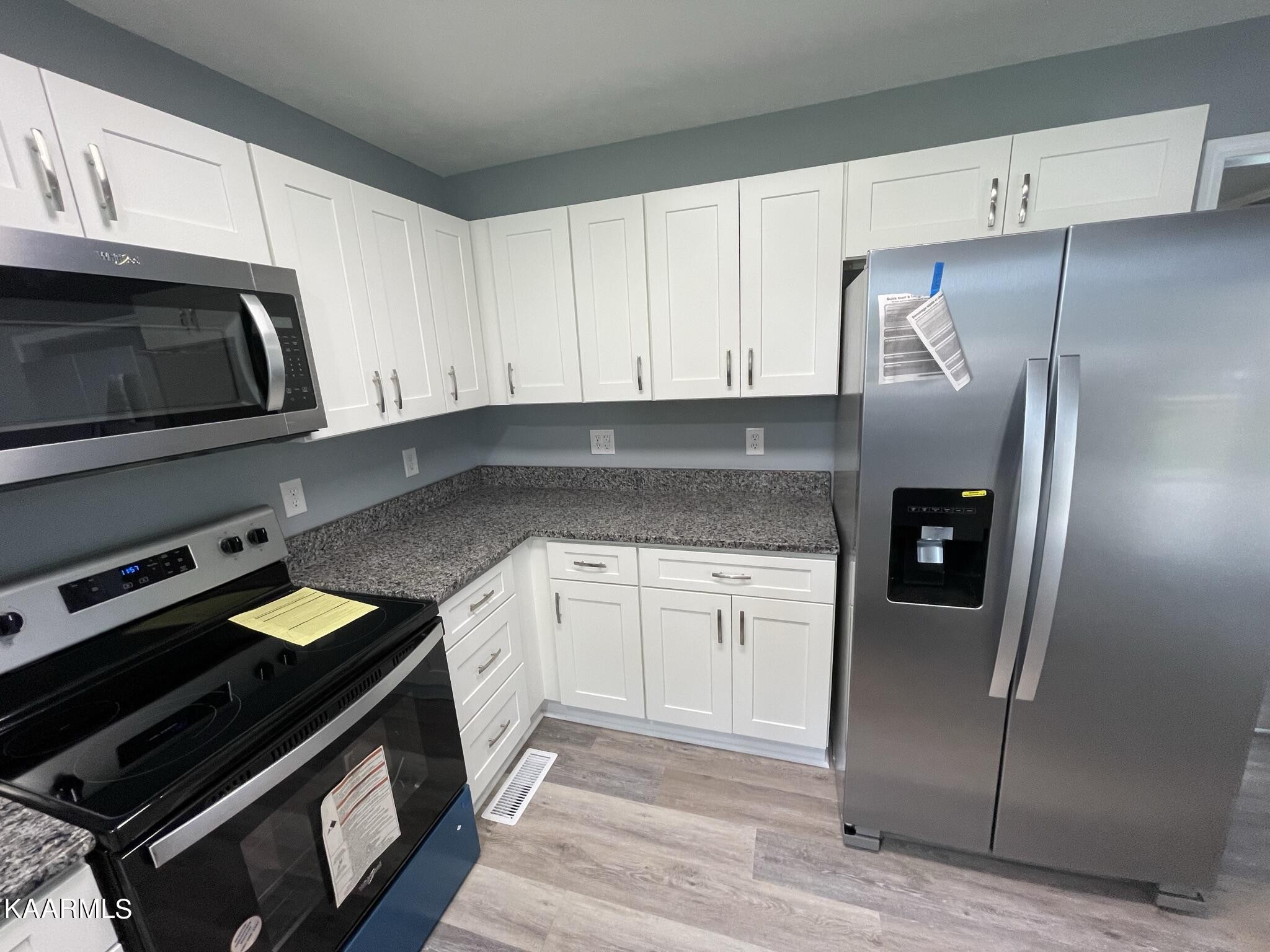 7170 Cedar Hill Road Talbott, TN 37877 - Photo 4 of 27 a kitchen with granite countertop a refrigerator stove and microwave