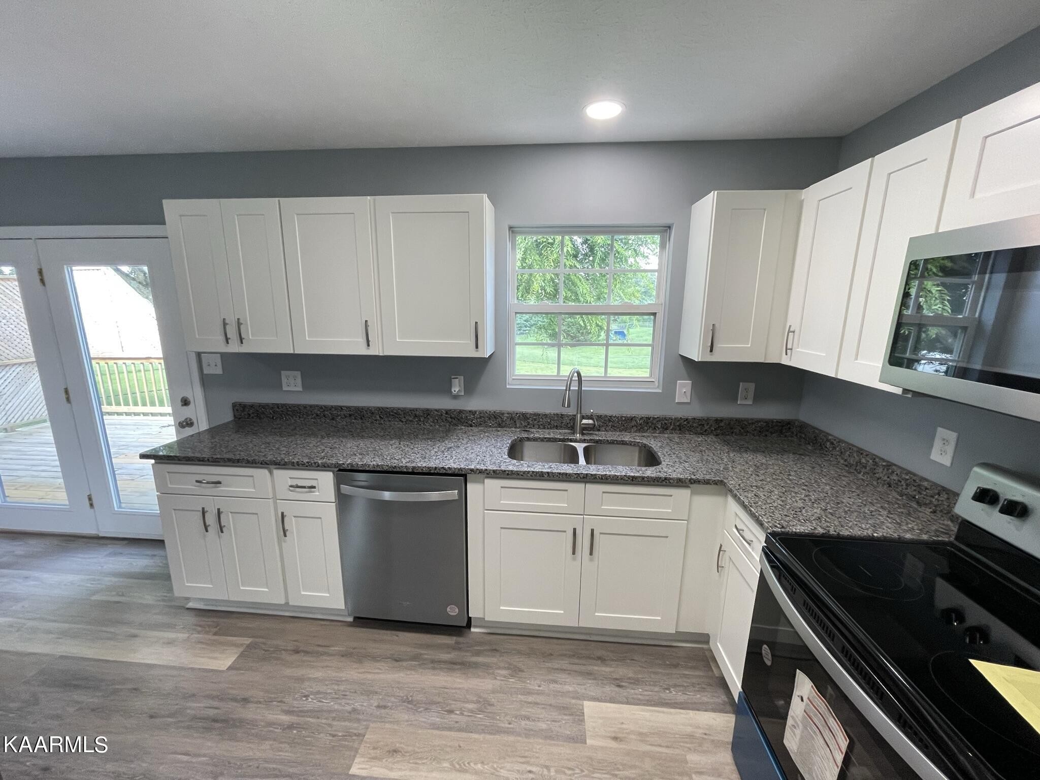 7170 Cedar Hill Road Talbott, TN 37877 - Photo 5 of 27 a kitchen with stainless steel appliances granite countertop a stove a sink and a microwave