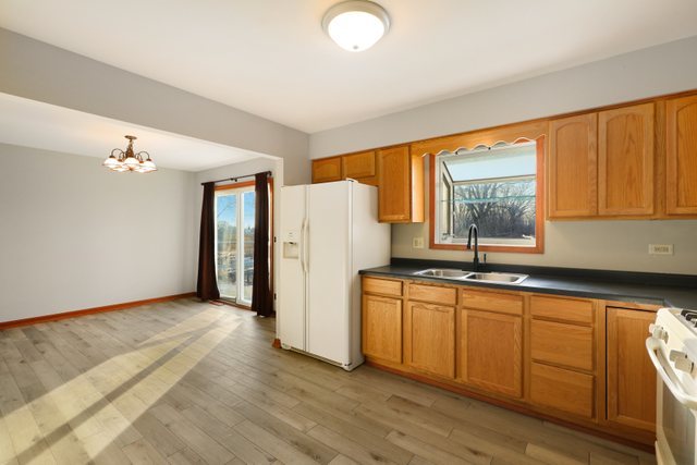 2394 Elm Road West Chicago, IL 60185 - Photo 9 of 28 a kitchen with stainless steel appliances granite countertop a refrigerator a sink dishwasher and wooden cabinets with wooden floor