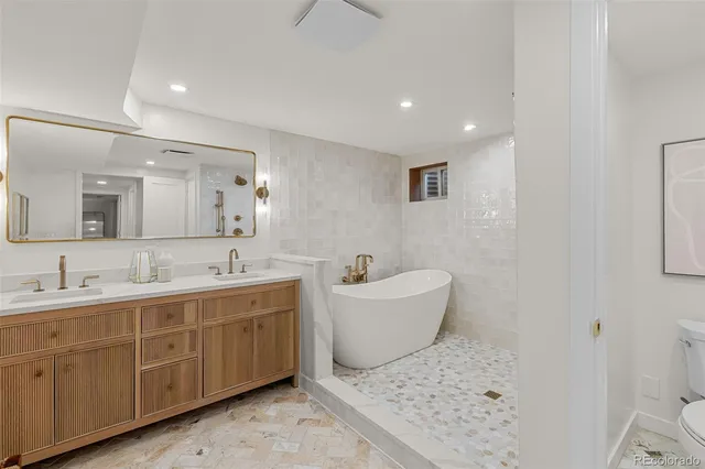 a bathroom with a tub sink and mirror