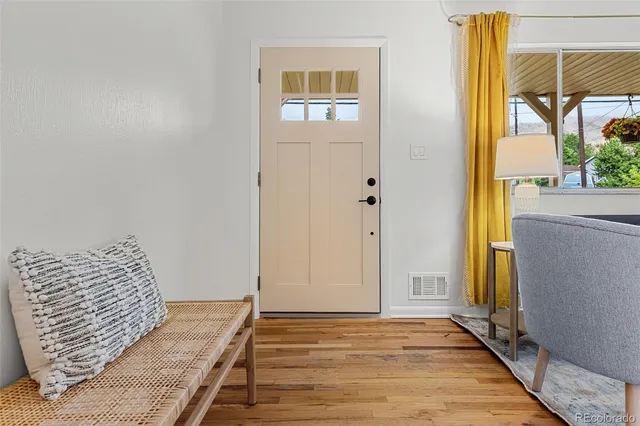 a view of a bedroom with wooden floor and a balcony
