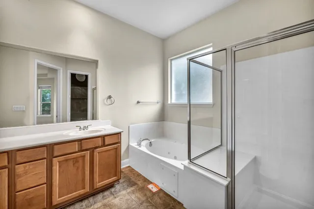 a bathroom with a tub sink and mirror